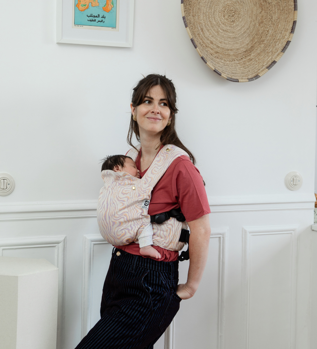 Maman portant son bébé dans un porte-bébé physiologique Bud & Blossom