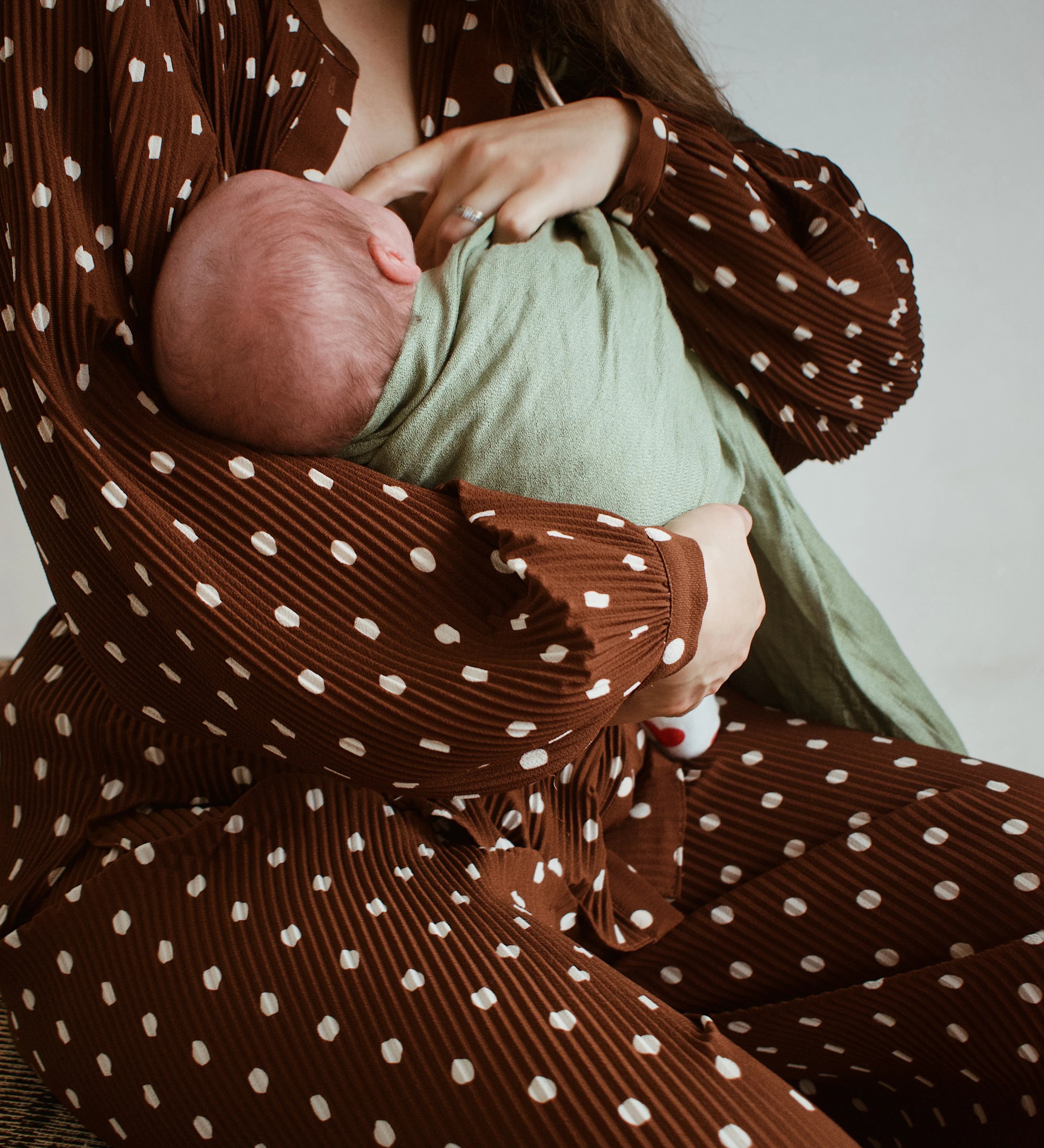 Photo d'une maman qui allaite son bébé en portage avec un sling Bud & Blossom