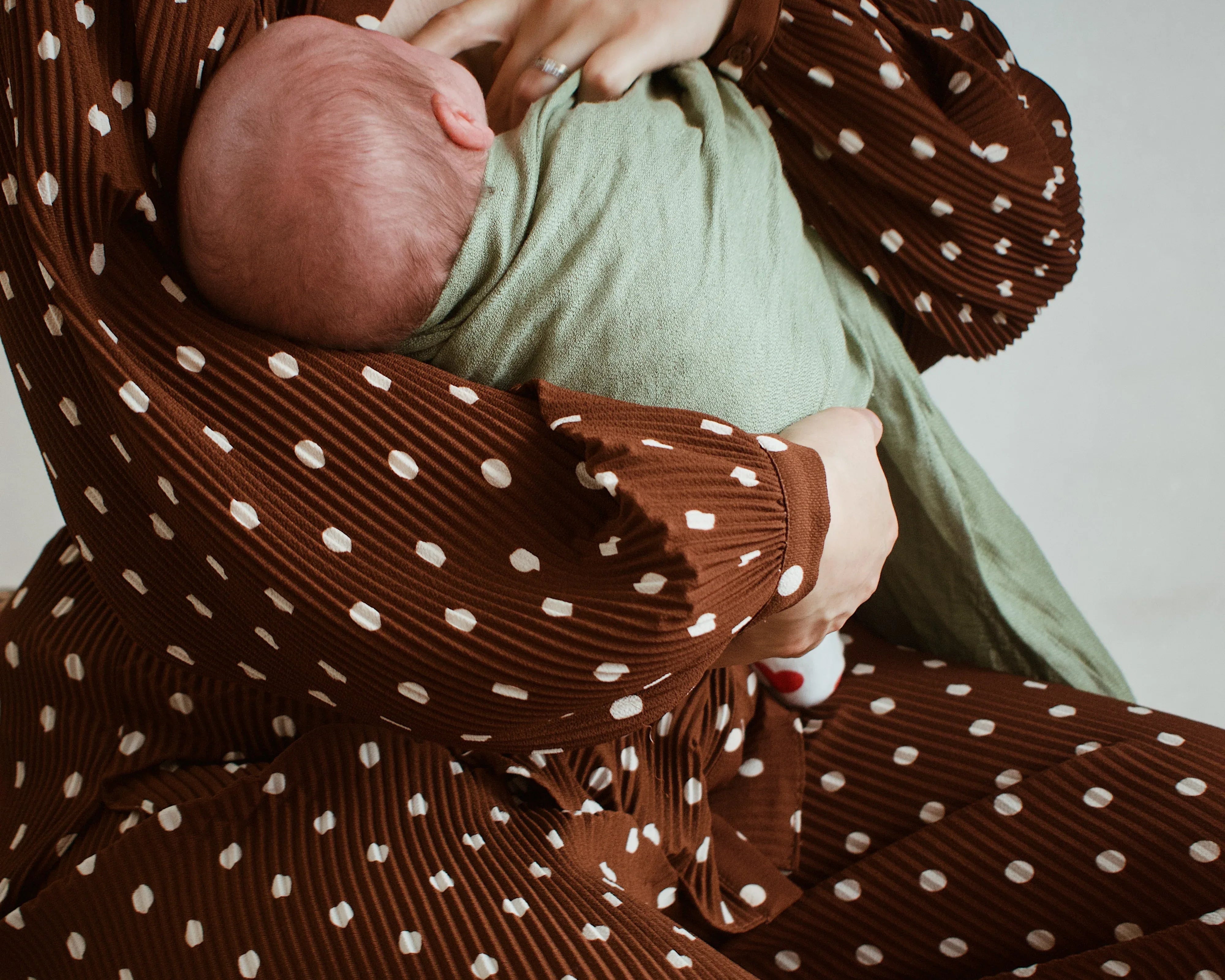Photo d'une maman qui allaite son bébé en portage avec un sling Bud & Blossom