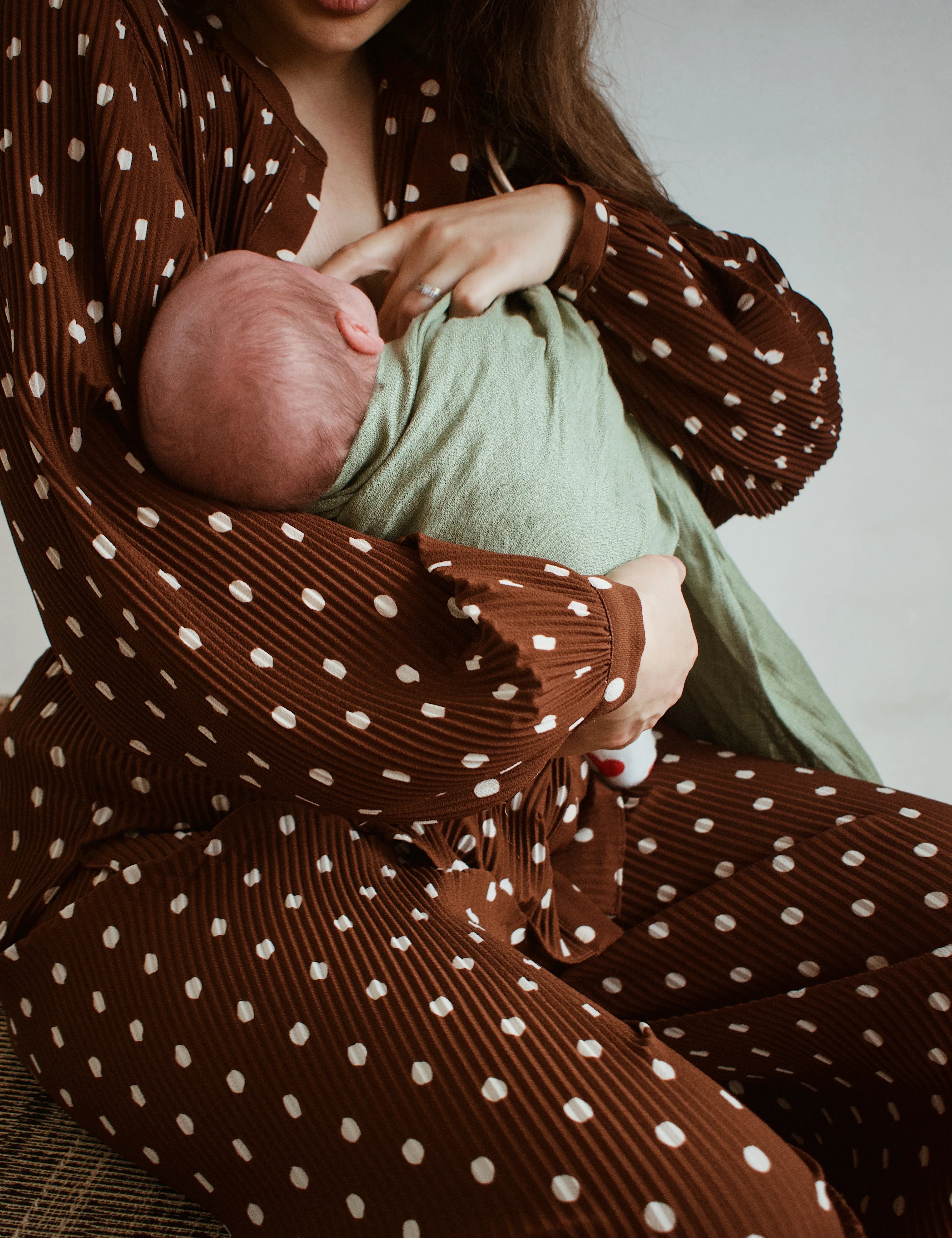 Photo d'une maman qui allaite son bébé en portage avec un sling Bud & Blossom