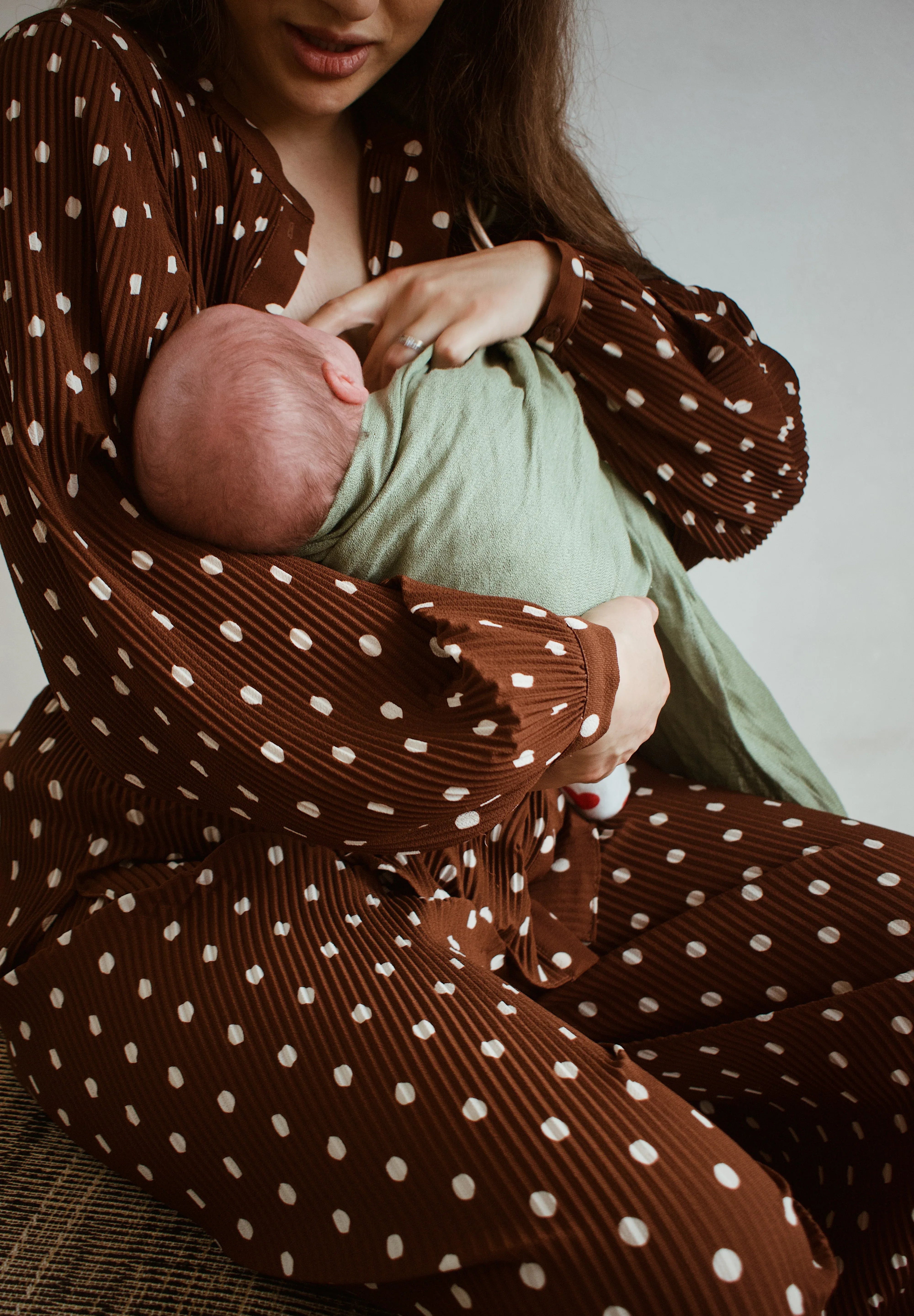 Photo d'une maman qui allaite son bébé en portage avec un sling Bud & Blossom