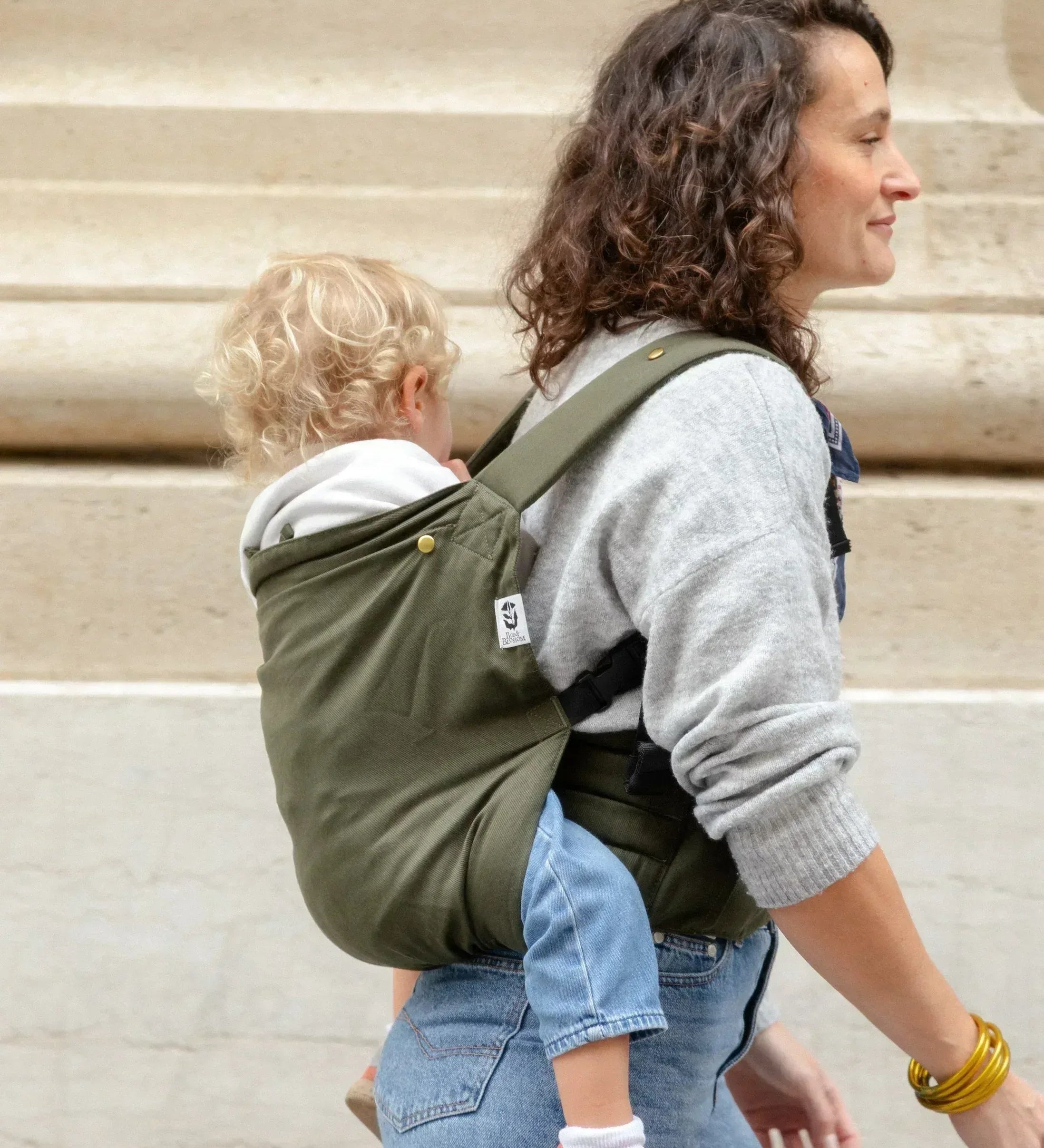 Bambin porté sur le dos dans un porte-bébé physiologique Exquis+ Toddler.