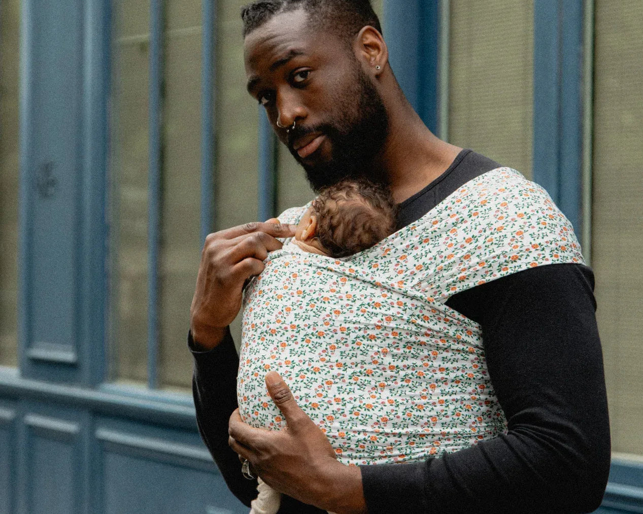 Papa portant son bébé en écharpe de portage Wrap Bud & Blossom, contre lui, en position ventrale physiologique.