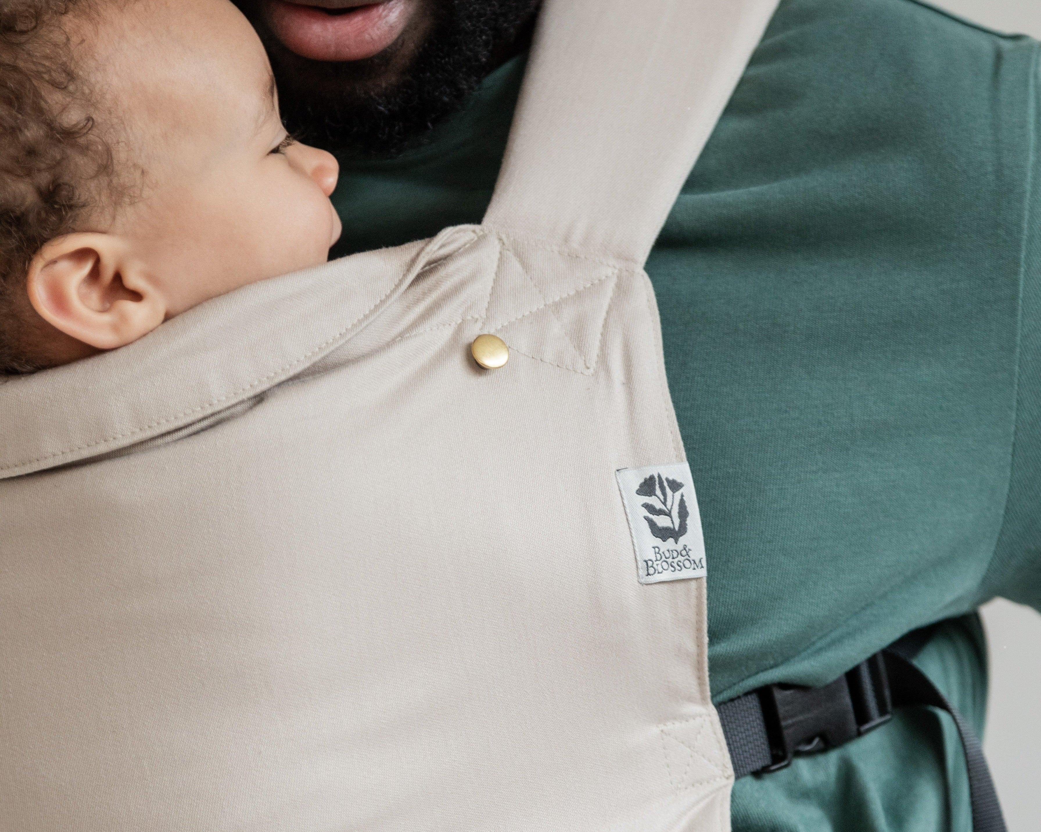 Papa portant son bébé face à lui, en position physiologique