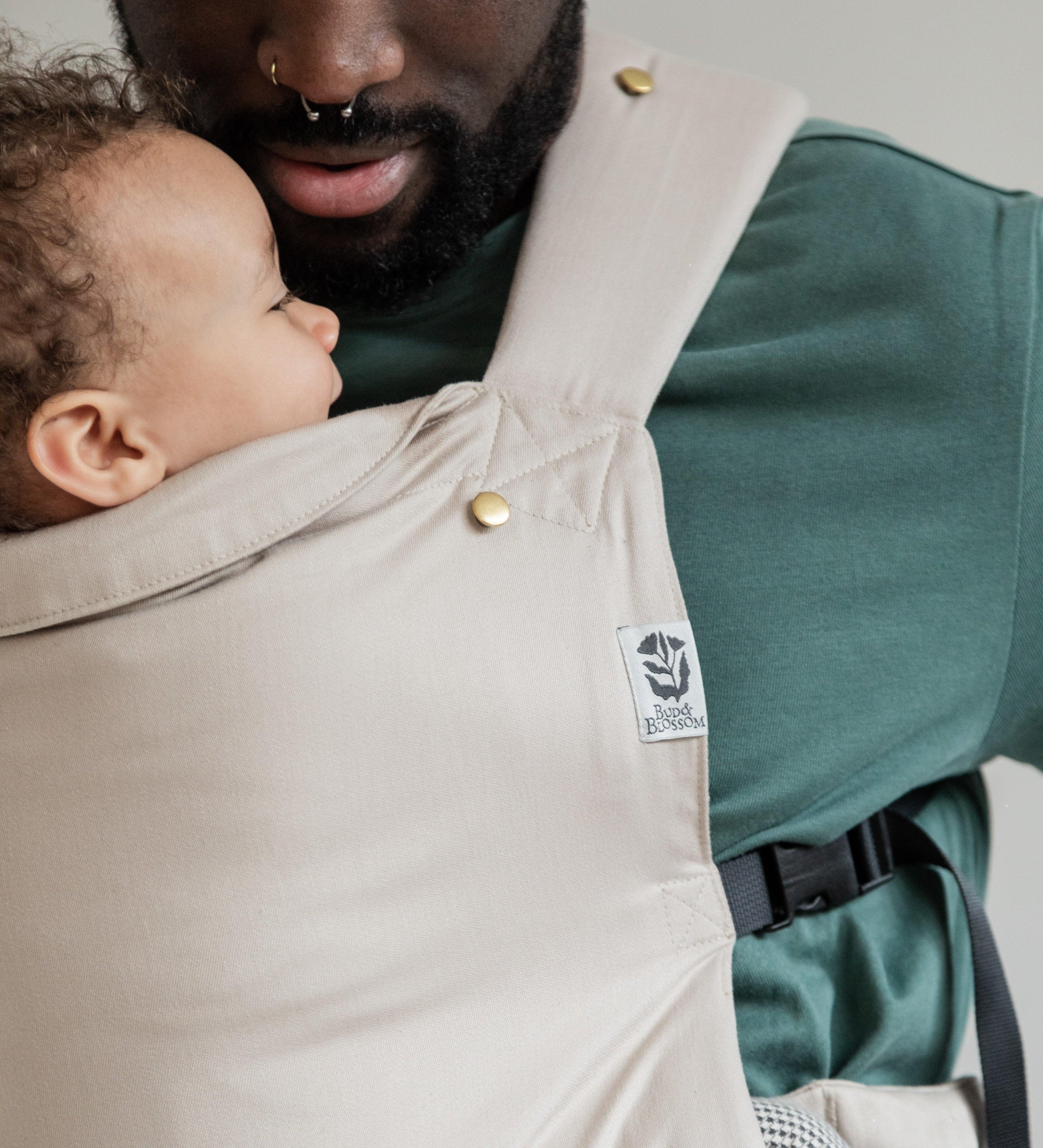 Papa portant son bébé face à lui, en position physiologique