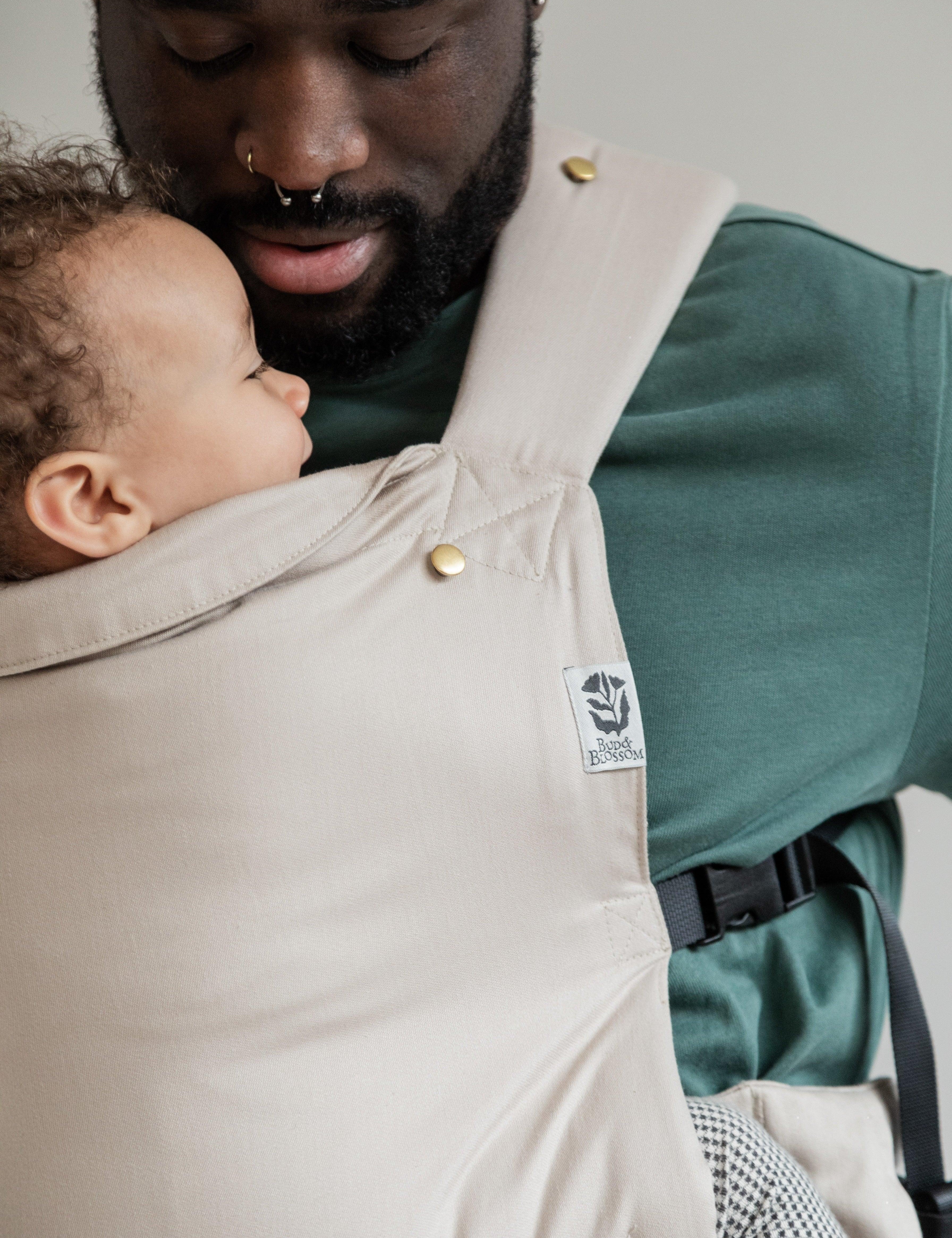 Papa portant son bébé face à lui, en position physiologique