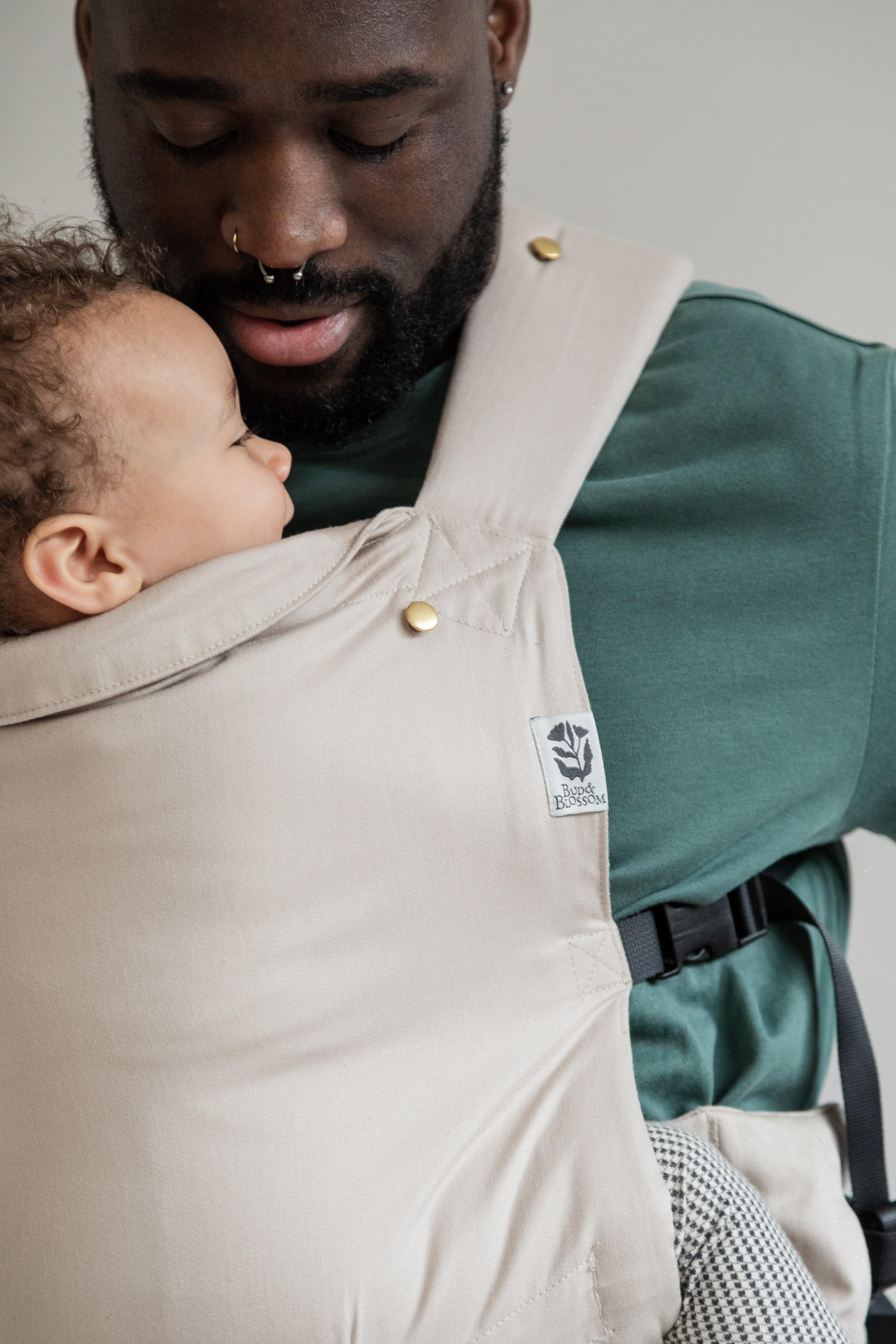 Papa portant son bébé face à lui, en position physiologique
