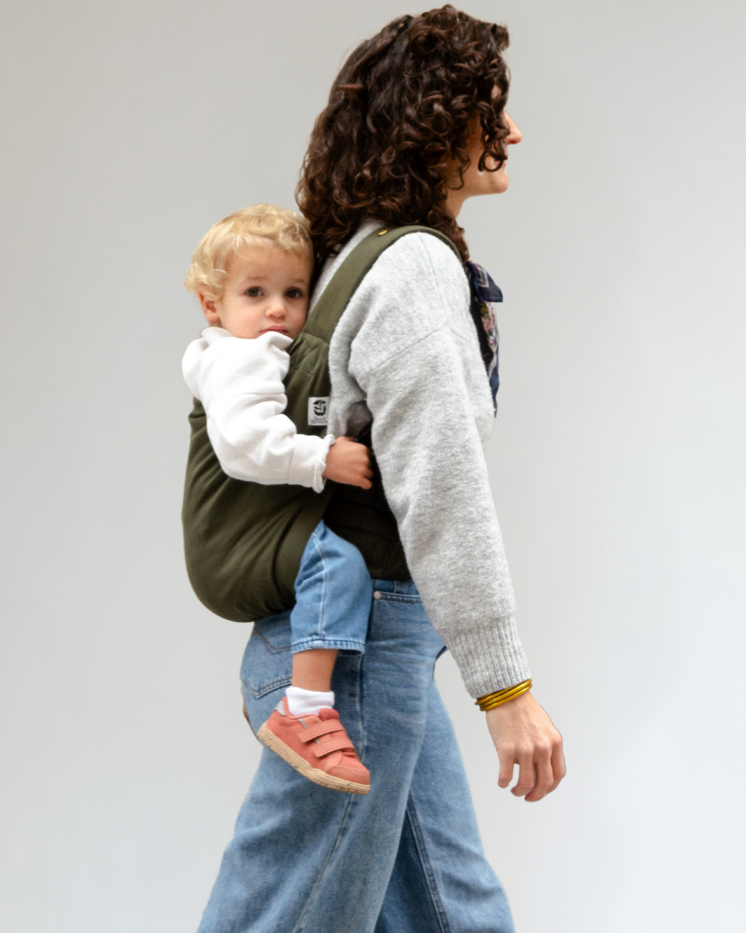 Enfant de 3 ans porté en porte-bébé Exquis+ Toddler sur le chemin de l’école