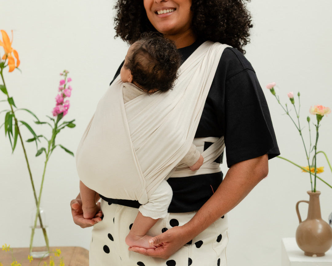 Nourrisson dormant contre son parent dans le porte-bébé Plume