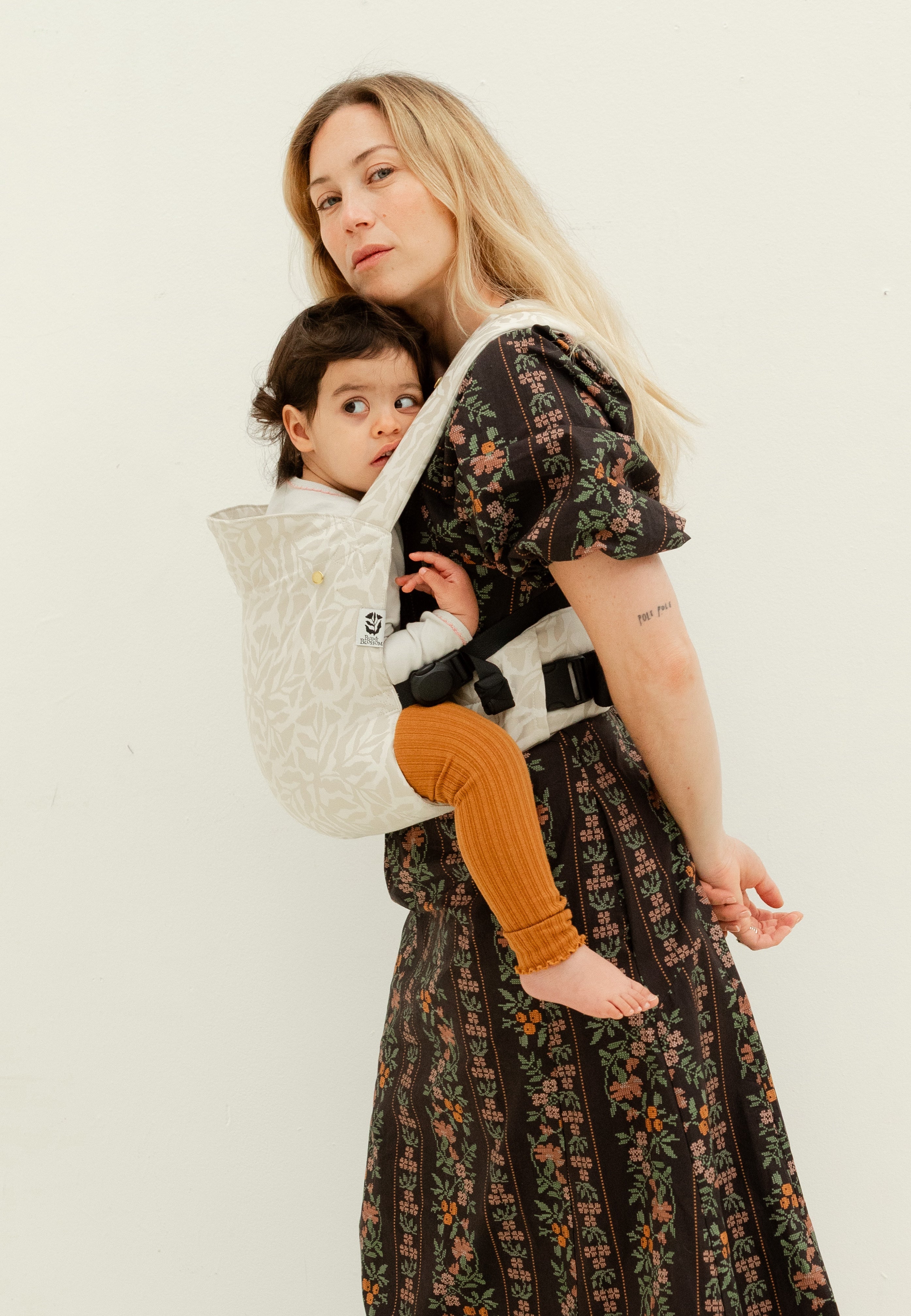 Maman utilisant le porte-bébé fleuri physiologique Exquis avec son bambin de 2 ans