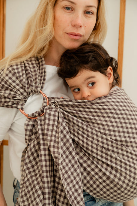 bébé fille de 2 ans porté dans le sling en lin coloris vichy marron de Bud & Blossom