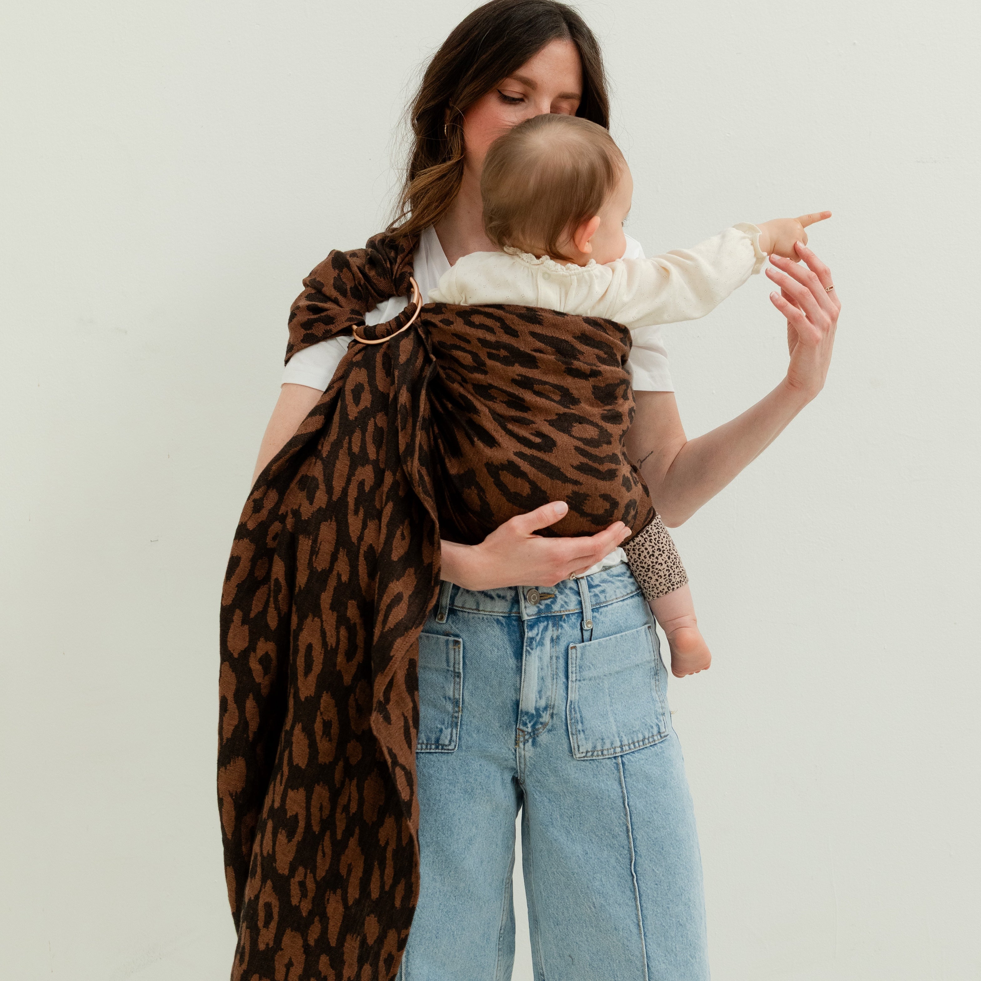 Maman portant son bébé dans un ring sling en lin motif léopard dès la naissance