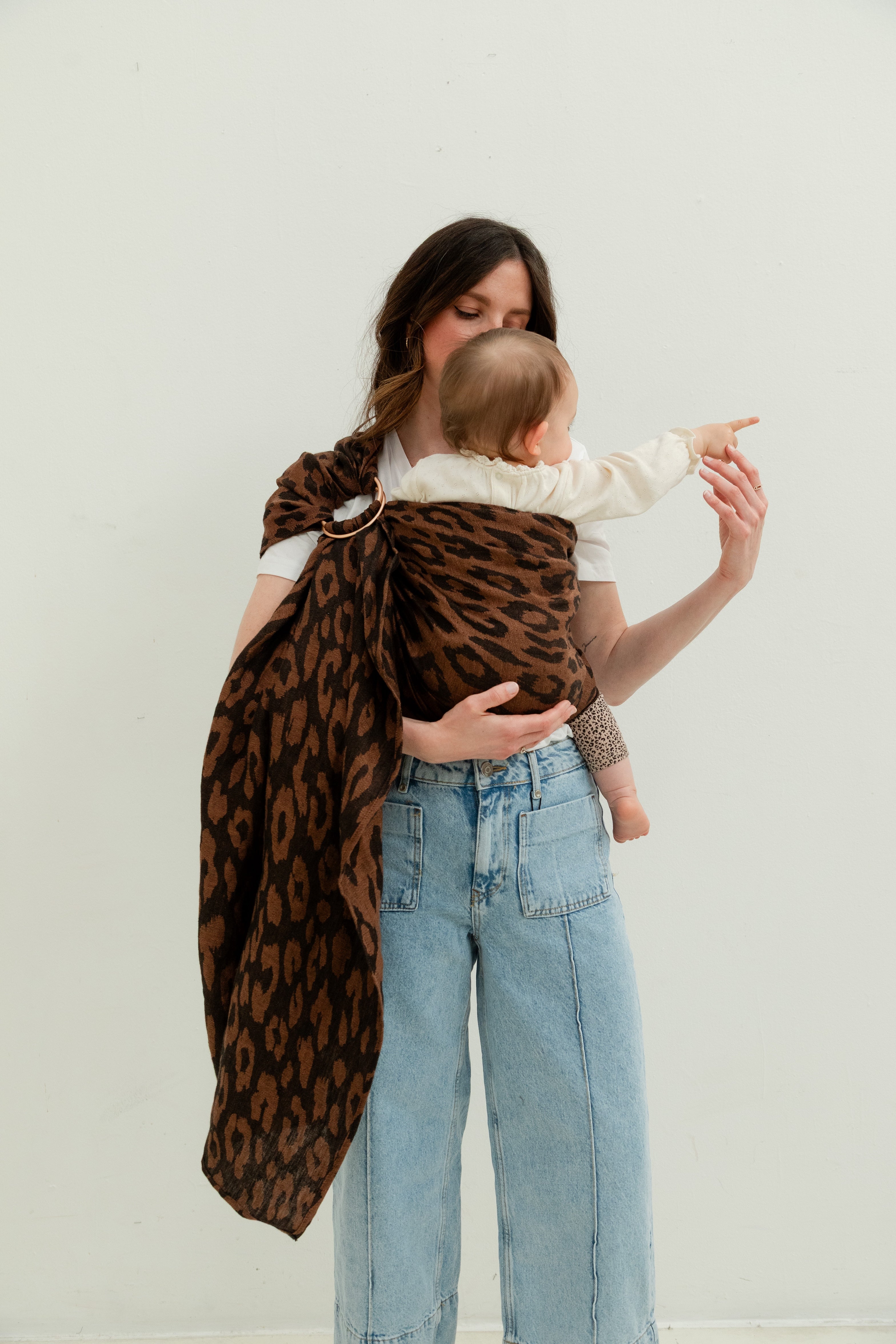 Maman portant son bébé dans un ring sling en lin motif léopard dès la naissance