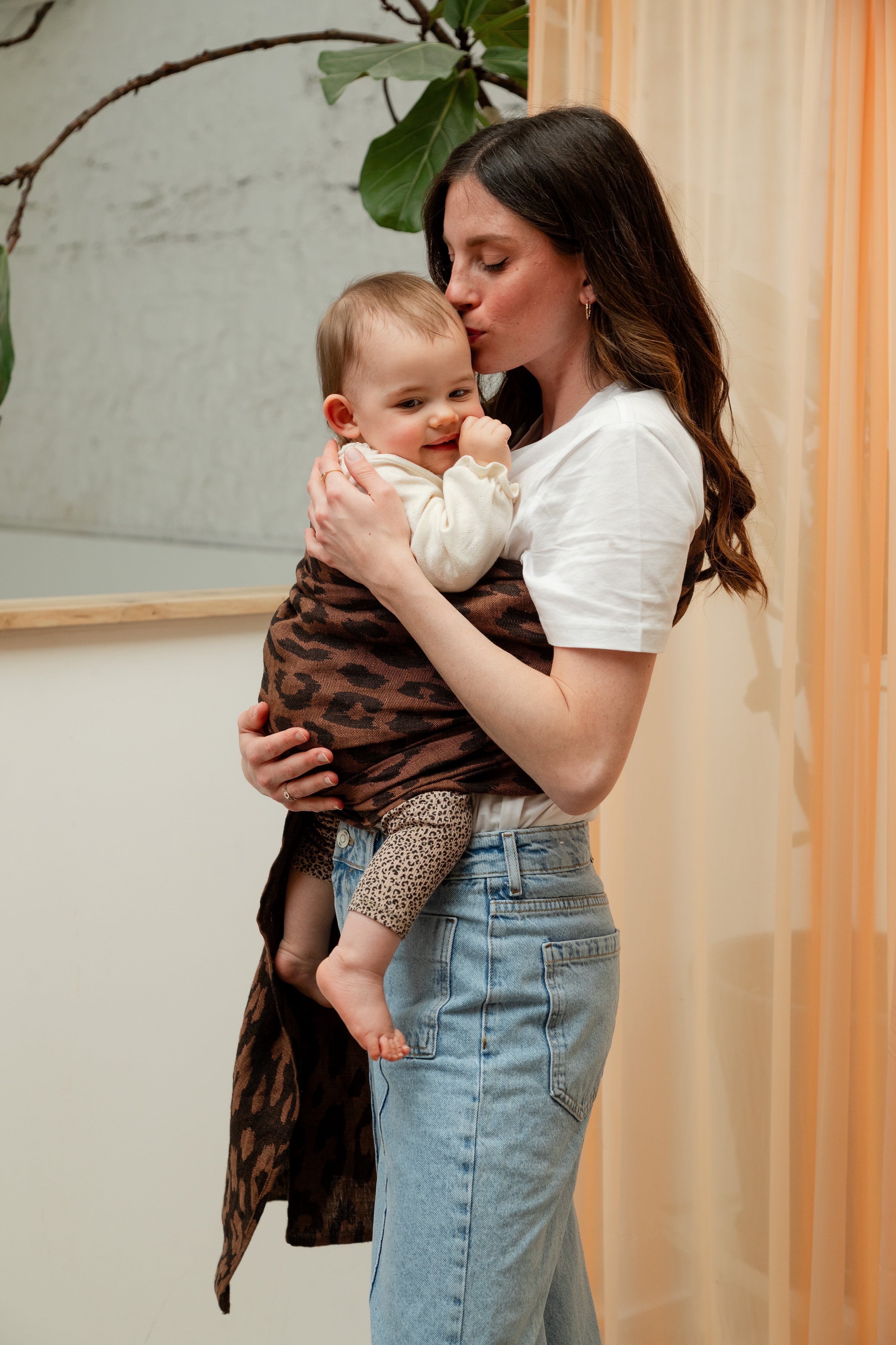 Maman et bébé en peau à peau dans un sling en lin motif léopard