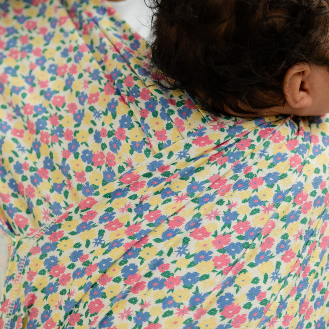 focus sur l'imprimé fleuri et multicolore du porte-bébé naissance Plume