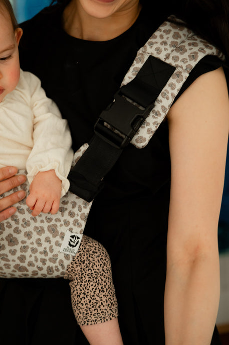 focus sur la boucle d'attache du porte-bébé de hanche motif léo